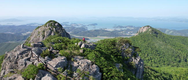 고흥의 진산(鎭山)인 팔영산 제7봉 칠성봉 정상 능선에 올라서서 지나쳐 온 봉우리를 뒤돌아봤다. 발을 딛고 있는 곳이 제7봉인 칠성봉이고, 왼쪽의 봉긋한 암봉이 제6봉인 두류봉, 오른쪽 저 아래가 제5봉인 오로봉이다.