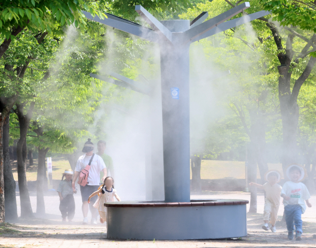 낮 최고 기온이 30도 안팎의 무더운 날씨를 보인 지난 12일 오후 인천 남동구 인천대공원에서 어린이들이 쿨링포그를 맞으며 더위를 식히고 있다.   뉴시스