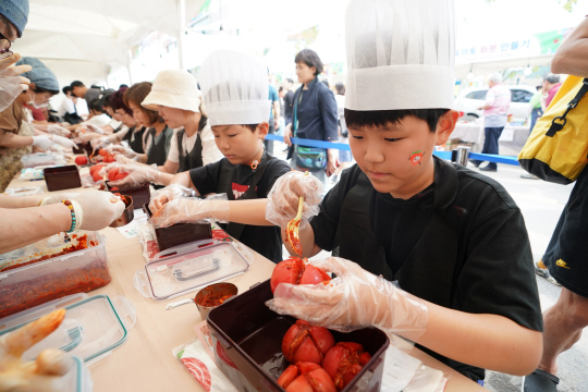 지난 15일 경기 광주시 퇴촌면에서 열린 ‘제22회 퇴촌토마토축제’ 현장에서 아이들이 토마토를 활용한 김치를 만들어보고 있다. 광주시청 제공