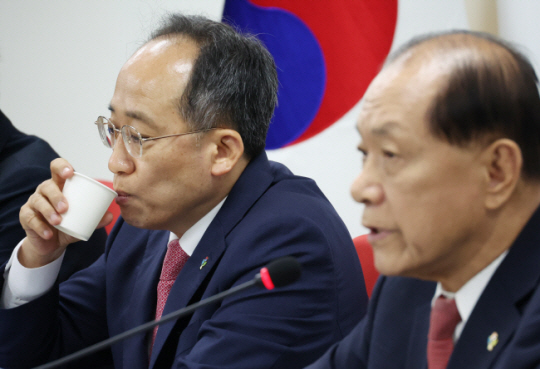 추경호(왼쪽) 국민의힘 원내대표가 17일 서울 영등포구 여의도 당사에서 열린 비상대책위원회에서 황우여 비대위원장의 발언을 경청하면서 물을 마시고 있다. 연합뉴스