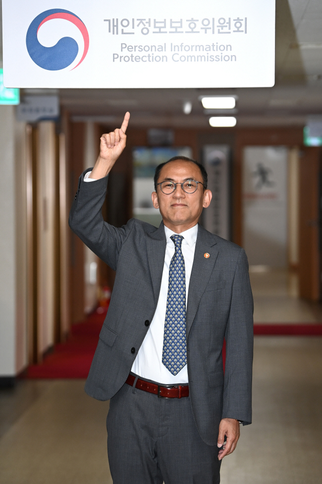 고학수 개인정보보호위원장이 지난 13일 서울 종로구 정부서울청사 4층 복도에서 개인정보위원회 간판을 가리키며 미소를 짓고 있다. 문호남 기자