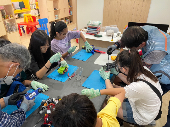 지난 18일 부산 금정구의 ‘우리동네 ESG센터’ 1호점에서 초등학생들이 자원순환 강사와 장난감을 해체하면서 자원이 어떻게 순환되는지 배우고 있다.  부산시청 제공