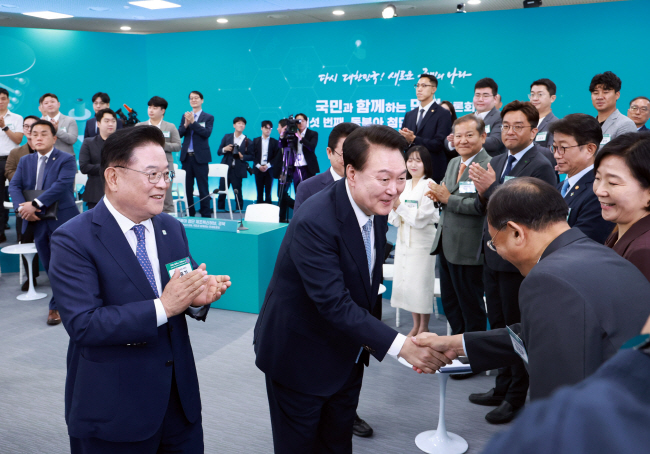 윤석열 대통령이 20일 오전 경북 경산시 영남대에서 열린 26차 ‘국민과 함께하는 민생토론회’에 입장하며 참석자와 악수하고 있다.  연합뉴스