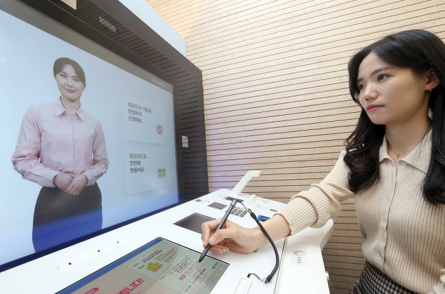 신한은행 직원이 디지털 데스크 속 인공지능(AI) 은행원의 안내에 따라 금융 업무를 보고 있는 모습. 신한금융 제공