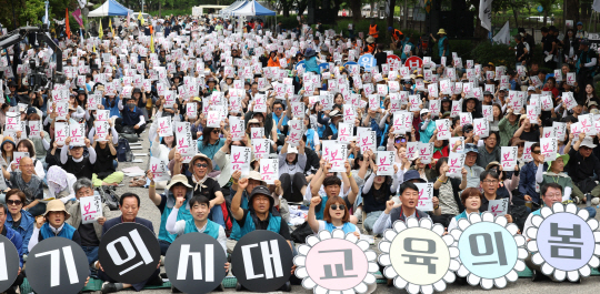 지난 5월 25일 오후 서울 여의도 국회 앞에서 열린 ‘전교조 창립 35주년 교사대회’에서 참가자들이 피켓을 들고 구호를 외치고 있다. 뉴시스