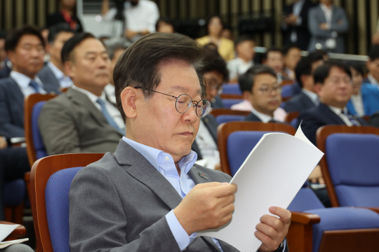 이재명 더불어민주당 대표가 20일 오후 서울 여의도 국회에서 열린 긴급 의원총회에서 안건 자료집을 보고 있다. 연합뉴스