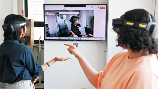 지난 26일 서울 마포구 합정동에 위치한 ‘아이유아이’ 사무실에서 경계선 지능 청년인 이지영(여·32·오른쪽) 씨와 김진영(여·33) 씨가 증강현실(AR) 웨어러블 기기인 홀로렌즈를 쓰고 교육 프로그램을 체험하고 있다. 백동현 기자