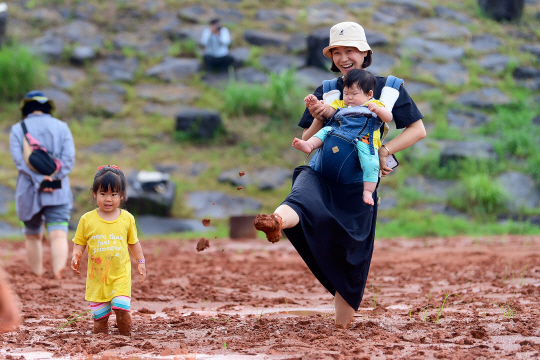 제주 서귀포 어싱광장이 지난해 7월 황토 맨발 걷기 체험장으로 개장한 뒤 한 주부가 아이들과 맨발걷기 체험을 하고 있다.  서귀포시청 제공