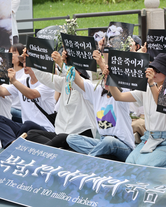 초복인 15일 오전 서울 종로구 보신각 앞에서 동물해방물결 주최로 열린 ‘2024 복날추모행동’ 집회에서 참석자들이 손팻말을 들고 구호를 외치고 있다. 연합뉴스