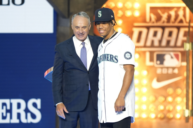 롭 맨프레드(왼쪽) MLB 커미셔너가 15일(한국시간) 2024 MLB 드래프트에서 전체 15순위로 시애틀 매리너스에 지명된 미시시피 주립대의 스위치 투수 주란젤로 세인자와 기념사진을 찍고 있다. AP 연합뉴스
