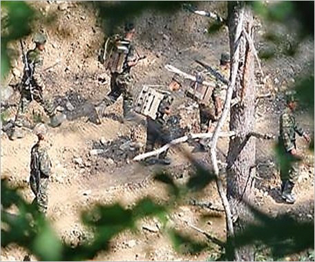 북한군이 최근 폭염 폭우 기간에도 아랑곳하지 않고 비무장지대(DMZ) 북측 지역에서 목함지뢰 추정 등짐을 지고 지뢰 매설 작업을 진행하고 있다. 합동참모본부 제공
