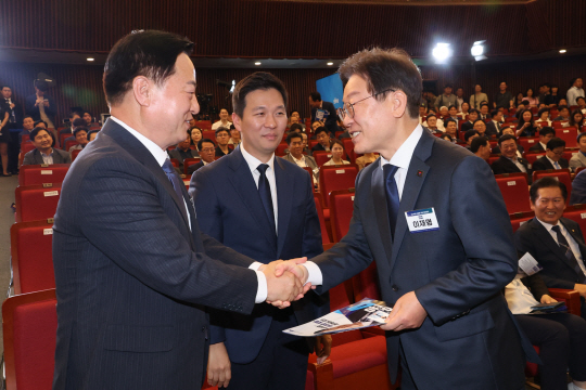 지난 14일 오후 서울 여의도 국회도서관 강당에서 열린 더불어민주당 8·18 전당대회 최고위원 선출을 위한 예비경선에서 이재명(오른쪽)·김두관(왼쪽), 김지수(가운데) 당 대표 후보들이 인사를 나누고 있다. 연합뉴스