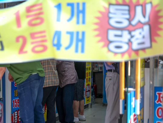 지난 14일 오전 서울시내 한 복권판매점에서 방문객들이 복권을 구매하고 있다. 뉴시스