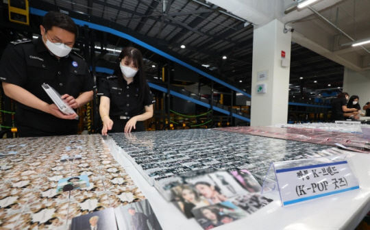 23일 오전 인천 연수구 인천본부세관 통합검사센터 해상특송물류센터에서 세관 직원들이 압수된 짝퉁 K팝 굿즈를 살펴보고 있다. 연합뉴스