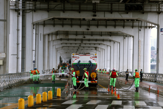 중부지방에 내린 집중호우로 서울 잠수교가 차량과 보행자 통행이 저면 통제되고 있는 가운데 19일 오전 서울 서초구 잠수교에서 복구 작업을 벌이고 있다.  윤성호 기자