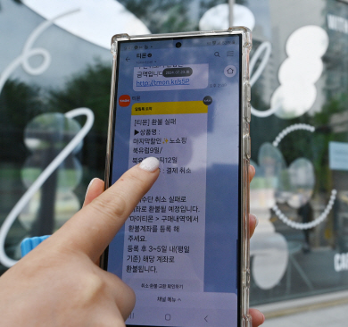 25일 오전 서울 강남구 티몬 본사 앞에서 한 소비자가 ‘환불 실패’ 문자를 보여주고 있다. 백동현 기자