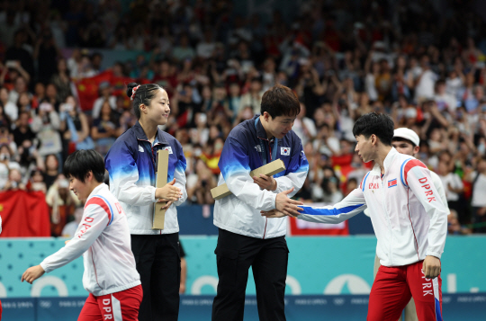 30일 오후(현지시간) 프랑스 파리 아레나 파리 쉬드4에서 열린 2024파리올림픽 탁구 혼합복식에서 동메달을 획득한 신유빈과 임종훈이 은메달을 차지한 북한 리정식-김금용과 악수하고 있다. 파리=윤성호 기자