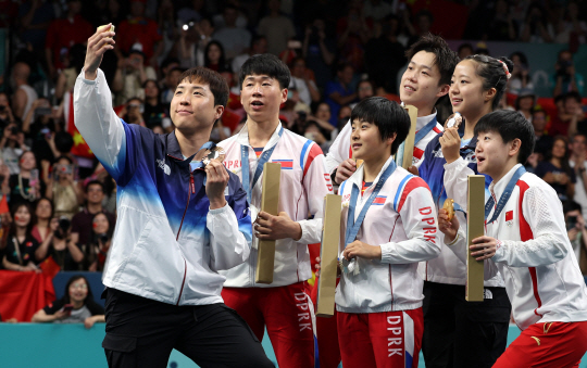 30일 오후(현지시간) 프랑스 파리 아레나 파리 쉬드4에서 열린 2024파리올림픽 탁구 혼합복식에서 동메달을 획득한 신유빈과 임종훈이 은메달을 차지한 북한 리정식-김금용과 셀카를 찍고 있다. 파리=올림픽사진공동취재단