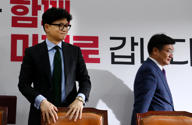 한동훈(왼쪽) 국민의힘 대표가 1일 국회에서 열린 최고위원회의에서 자리에 앉으려고 하고 있다. 뒤로 정점식 정책위의장이 지나가고 있다.  곽성호 기자