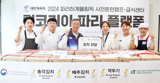 남상희(왼쪽 네 번째)한국농수산식품유통공사 파리지사장과 정동국(세 번째) 국가대표선수촌 부촌장 등이 지난달 31일(현지시간) 김치전달식에 참석해 기념촬영을 하고 있다.(aT 제공)