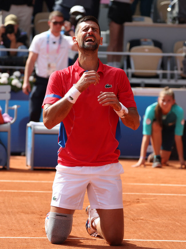 세르비아의 노바크 조코비치가 5일 오전 프랑스 파리의 롤랑가로스 경기장에서 끝난 2024 파리올림픽 테니스 남자단식 결승전에서 승리한 뒤 코트에 무릎을 꿇은 채 눈물을 흘리고 있다.  UPI 연합뉴스