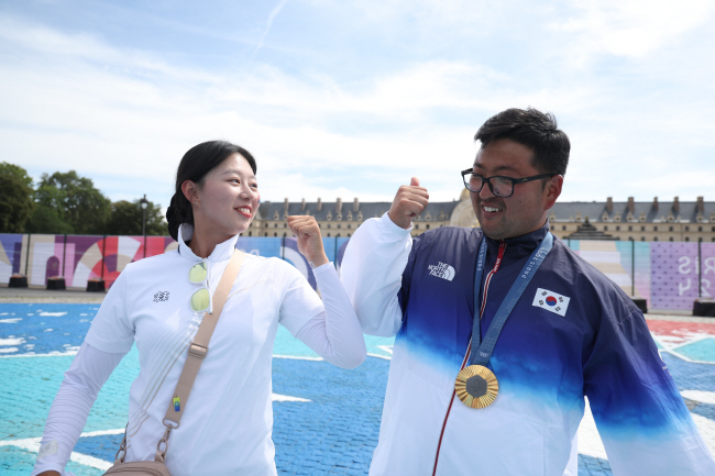 임시현(왼쪽)이 4일 프랑스 파리의 레쟁발리드에서 열린 2024 파리올림픽 양궁 남자 개인전 시상식에서 금메달을 받은 김우진을 축하하고 있다. 둘은 남녀 개인전과 단체전, 혼성전까지 나란히 3관왕을 차지했다. 연합뉴스