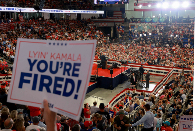 도널드 트럼프 전 미국 대통령이 지난 3일 조지아주 애틀랜타의 유세장에서 연설하는 가운데 한 지지자가 들고 있는 ‘거짓말쟁이 카멀라, 당신은 해고야’라고 적힌 팻말이 눈에 띈다.  AFP 연합뉴스