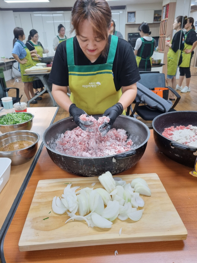 우리 마을 봉사단이 지난 7월 26일 초록우산 전북종합사회복지관 프로그램실에서 돼지 떡갈비를 만들고 있는 모습.  초록우산 제공