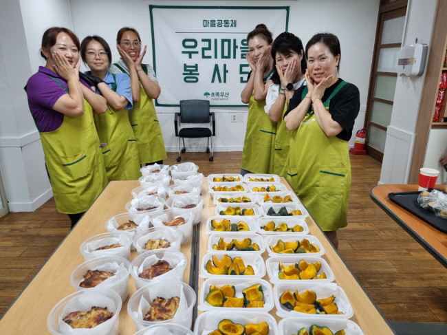 저소득 가정 아이들에게 건강한 먹거리를 지원하는 ‘우리 마을 봉사단’이 지난 7월 12일 전북 전주시 초록우산 전북종합사회복지관 프로그램실에서 치킨바비큐와 단호박구이를 준비한 후 환하게 웃고 있는 모습.  초록우산 제공