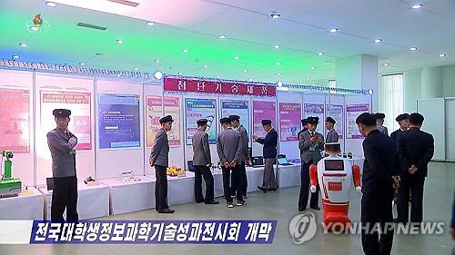 지난 24일 평양 과학기술전당에서 개막된 ‘전국대학생정보과학기술성과전시회장을 찾은 대학생들이 전시된 인공지능 (AI)로봇을 살펴보고 있다. 조선중앙TV 화면 캡처