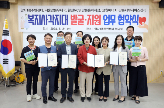 이수희(앞줄 가운데) 강동구청장이 지난 21일 복지사각지대 발굴 지원 업무협약식에서 참석자들과 기념사진을 찍고 있다. 강동구청 제공