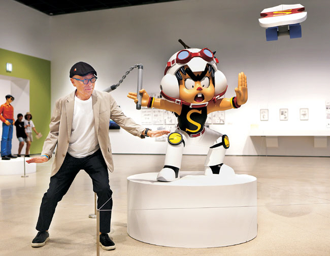 애니메이션으로 대히트를 친 ‘날아라 슈퍼보드’의 미스터 손 동상 옆에서 비슷한 포즈를 취하고 있는 허영만 작가.  전남도립미술관 제공