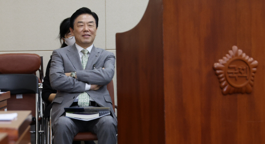 김형석 독립기념관장이 26일 오전 국회에서 열린 정무위원회 전체회의에서 더불어민주당 박상혁 의원의 질의 도중 자신과 관련된 발언이 나오자 팔짱을 낀 채 웃음을 짓고 있다. 이 모습을 본 강준현 더불어민주당 간사는 김 관장이 야당 의원 발언을 들으며 "비웃는 표정을 짓고 있다"고 지적하며 경고를 줄 것을 윤한홍 위원장에게 요구했다. 연합뉴스