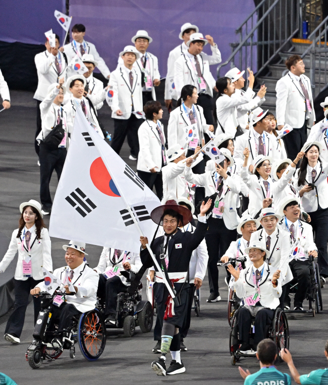 대형 태극기를 든 기수 최용범을 앞세운 한국 선수단이 29일 오전 프랑스 파리의 콩코르드 광장에서 열린 2024 파리패럴럼픽 개회식에서 입장하고 있다. 사진공동취재단