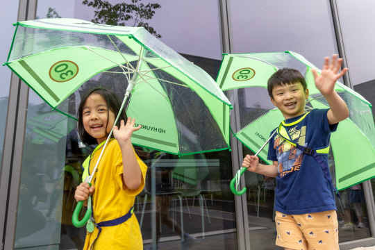 어린이들이 HD현대가 배포한 안전우산과 함께 기념촬영을 하고 있다. HD현대 제공