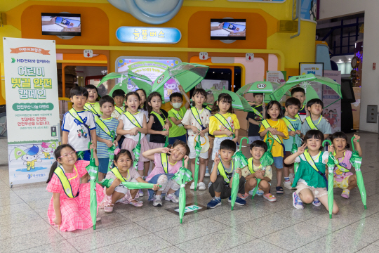 어린이들이 HD현대가 배포한 안전우산과 함께 기념촬영을 하고 있다. HD현대 제공