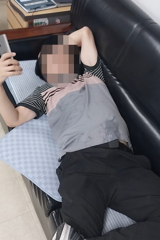 지난달 서대문구청 종합상황실에서 음주 상태의 한 민원인이 소파에 누워 자신의 스마트폰으로 근무 중인 직원들을 촬영하고 있다. 서대문구청 제공