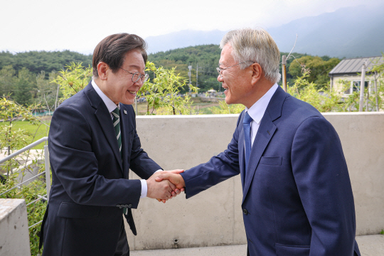 문재인 전 대통령이 8일 오후 경남 양산 평산마을 사저를 예방한 더불어민주당 이재명 대표(왼쪽)와 악수하고 있다. 더불어민주당 제공, 연합뉴스
