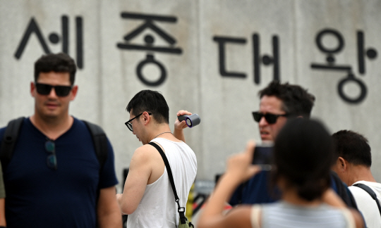 폭염이 계속 되고 있는 가운데 추석 연휴 마지막 날인 18일 서울 광화문 광장에서 한 관광객이 휴대용선풍기로 더위를 식히고 있다. 박윤슬 기자