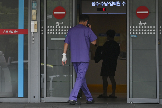 추석 연휴가 끝난 19일 오전 서울 시내 한 대학병원에서 손목과 손에 붕대를 한 의료진이 통화를 하며 응급실로 들어서고 있다.    백동현 기자