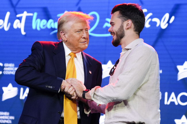 19일 도널드 트럼프(왼쪽) 전 대통령이 워싱턴DC에서 열린 이스라엘·미국 협의회 전국회의에서 하마스에 인질로 붙잡혔다가 구출된 안드레이 코슬로프와 악수하고 있다.  AP 연합뉴스