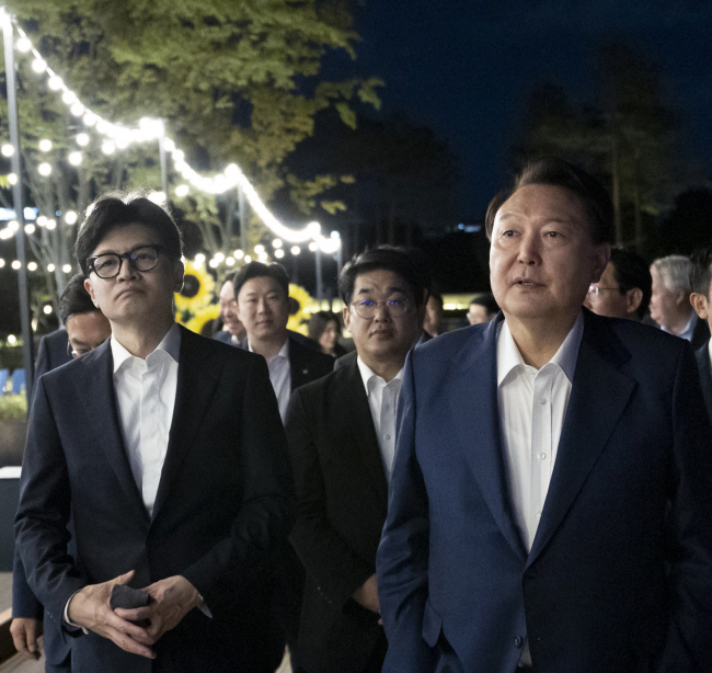 윤석열 대통령이 24일 서울 용산 대통령실 앞 분수 정원에서 열린 국민의힘 지도부 초청 만찬을 마친 뒤 한동훈(왼쪽) 대표 등과 함께 산책하고 있다. 대통령실 제공