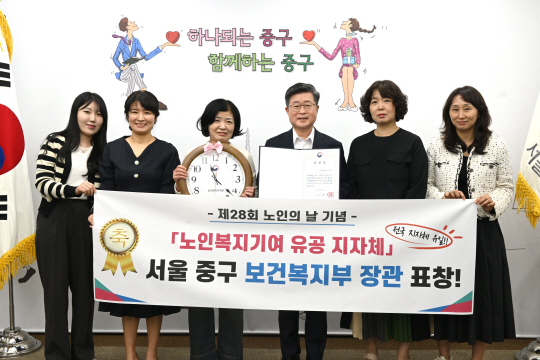 김길성(오른쪽 세번째) 중구청장과 중구청 직원들이 보건복지부 장관 표창장을펼쳐보이고 있다.중구청 제공