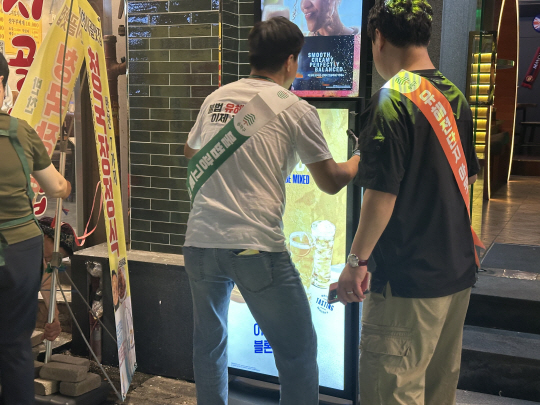 송파구 관계자들이 신천동과 방이동 먹자골목 일대에서 불법 광고물 근절을 위한 민·관·경 야간 합동단속 및 캠페인을 펼치고 있다. 송파구청 제공