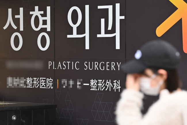 7일 오전 서울 강남구 신사동에 위치한 성형외과 앞을 한 시민이 지나고 있다. 건강보험심사평가원에 따르면 지난해 일반의원, 성형외과 등을 중심으로 건강보험 청구를 아예 하지 않은 비급여 중심 의료기관이 2221곳에 달했다.  백동현 기자