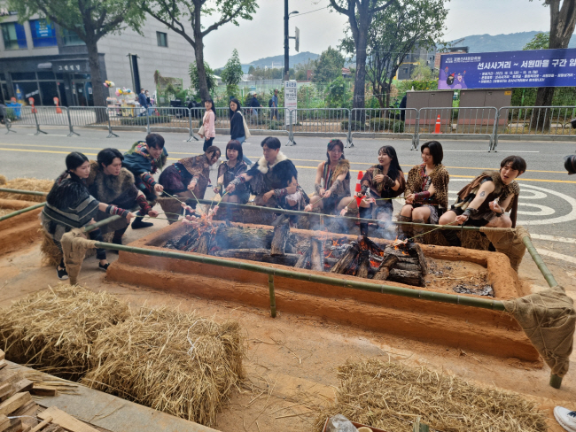 지난해 열린 강동선사문화축제에서 참가자들이 대형 화덕에서 꼬치구이를 해먹는 ‘선사 바비큐 체험’을 하며 즐거워하고 있다. 강동구청 제공
