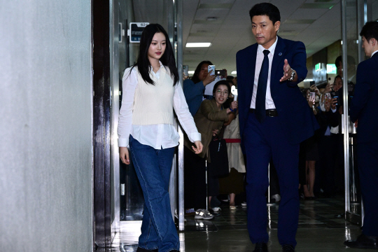 뉴진스 멤버 하니가 15일 국회에서 열린 환노위 국감에 증인으로 출석하기 위해 국회 경위의 안내를 받아 국감장으로 향하고 있다. 국회사진기자단