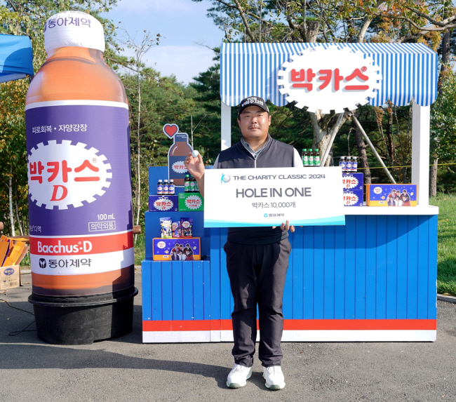 유송규가 17일 강원 양양의 설해원 더 레전드 코스에서 열린 KPGA투어 더채리티클래식 1라운드 11번 홀에서 프로 데뷔 첫 번째 홀인원을 성공한 뒤 부상으로 받은 박카스 1만 병과 함께 사진을 찍고 있다.  KPGA 제공