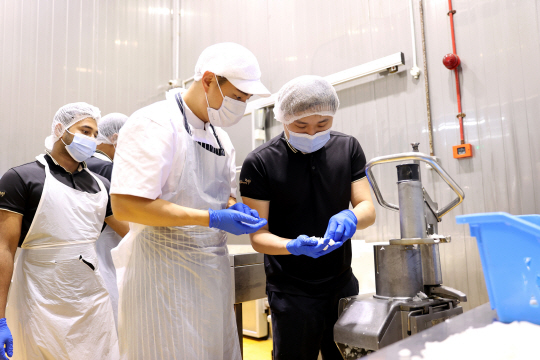 교촌에프앤비 본사 소속 직원(오른쪽 두 번째)이 말레이시아 마스터프랜차이즈(MF) 직원들에게 각종 운영 노하우를 전수하고 있다. 교촌에프앤비 제공