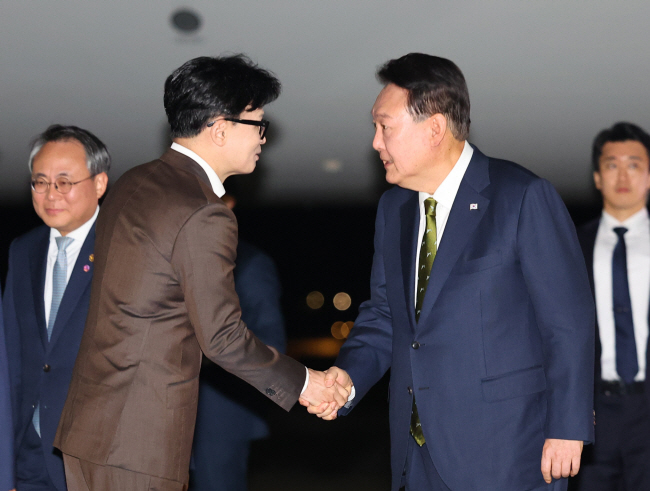 지난 11일 서울공항에서 한·아세안(동남아국가연합) 정상회의 일정 등을 마치고 귀국한 윤석열 대통령이 환영 나온 한동훈(왼쪽 두 번째) 국민의힘 대표와 악수하고 있다.  뉴시스